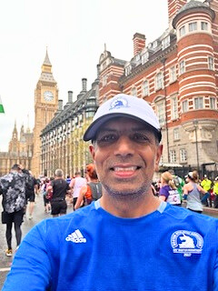 Mouli sports Duke blue gear as he stands in front of a classic red building in London.