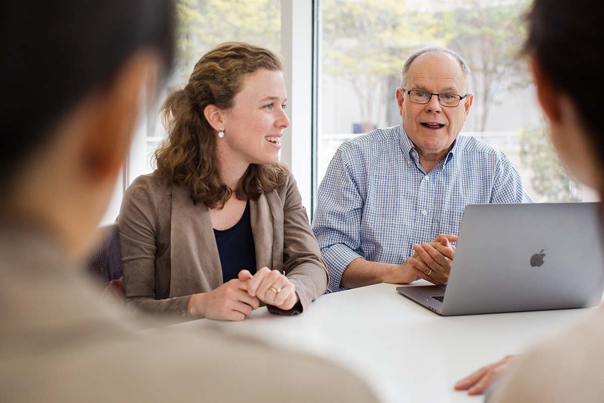 Professor Wes Cohen sitting with Strategy PhD students
